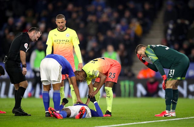 Leicester's Kelechi Iheanacho receives attention after a collision with Manchester City goalkeeper Ederson, right