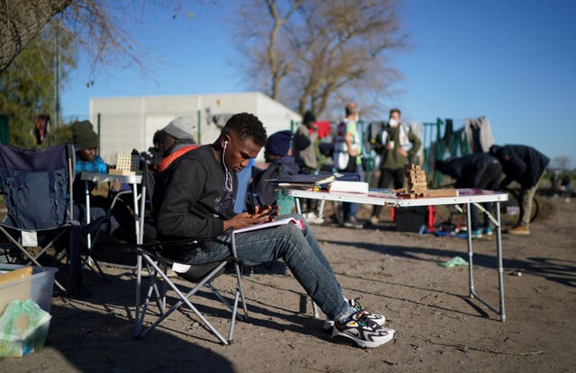 A man studies at the makeshift Calias camp