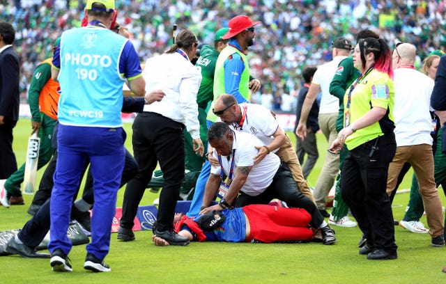 A pitch invader is tackled by security at Headingley