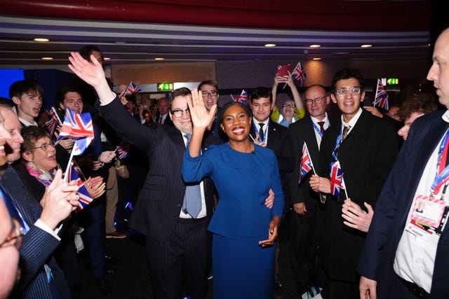 Kemi Badenoch smiling while walking through Tory supporters