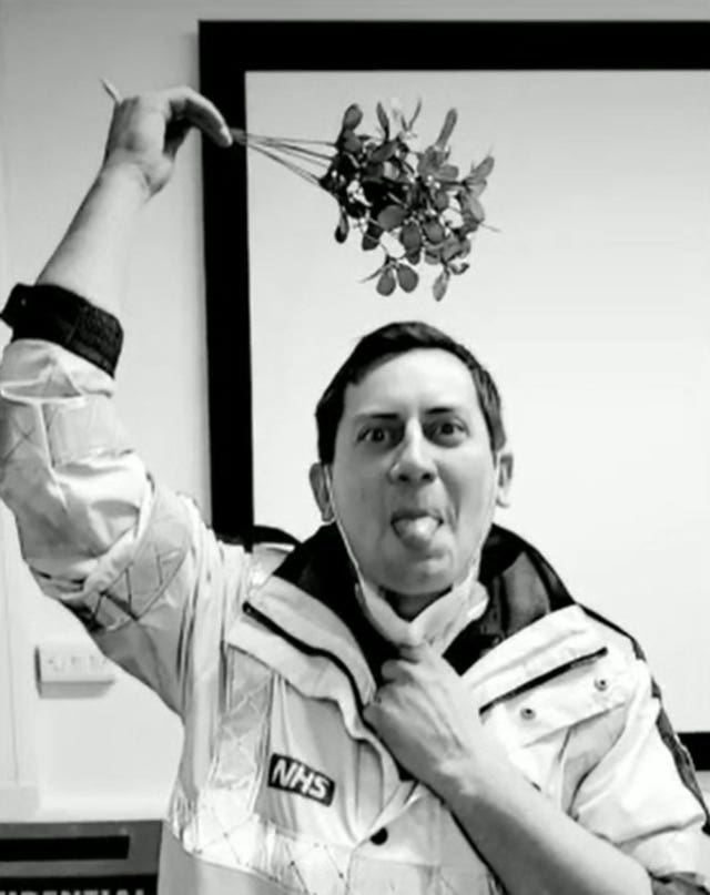 An NHS worker holding mistletoe