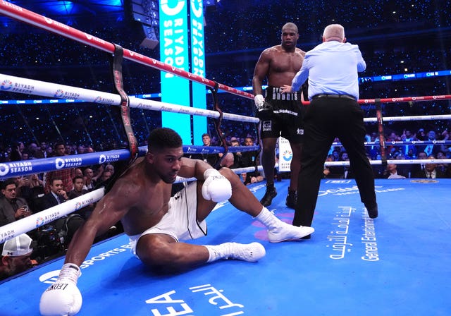 Anthony Joshua sits on the canvas after Daniel Dubois knocked him down at Wembley