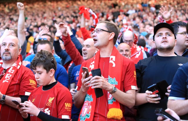 Liverpool fans check their mobile phones at Anfield