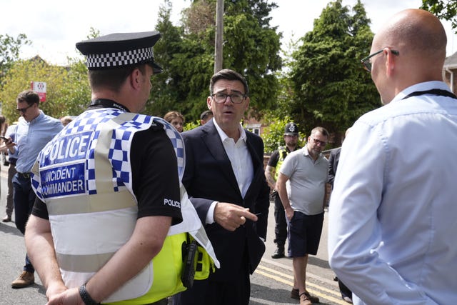 Andy Burnham speaking to police and other officials outside