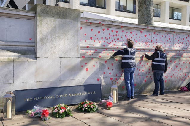 People painting red hearts on the memorial