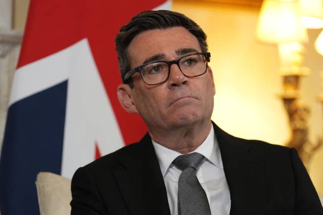 Head and shoulders photo of Andy Burnham, with a British flag behind him