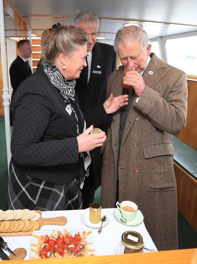 The Prince of Wales samples marmalade from Jane McCosh aboard the Lady Of The Lake, flagship vessel of the Ullswater Steamers company (Peter Byrne/PA)