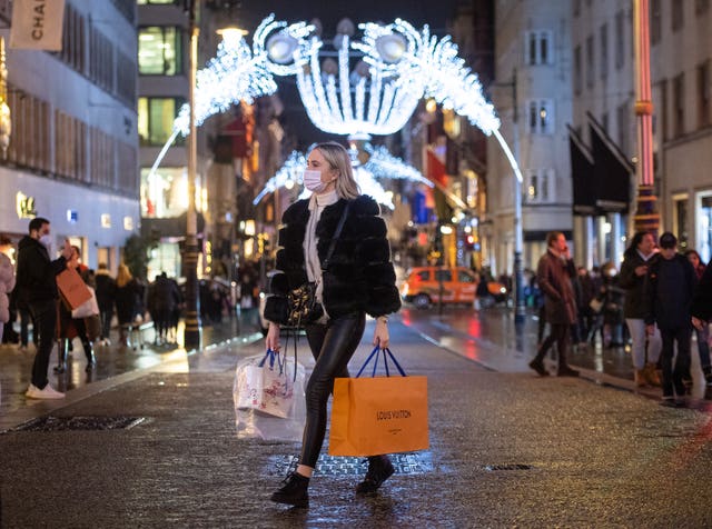 Shoppers pass Christmas light displays on New Bond Street in central London