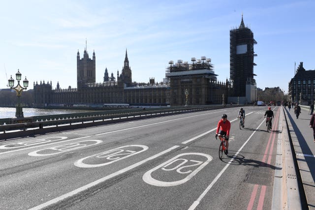 Cyclists ride across an empty Westminster Bridge