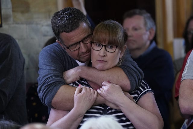 Villager Aundrea Watson is comforted during the meeting