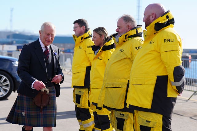 The King meeting four RNLI volunteers, who are dressed in yellow