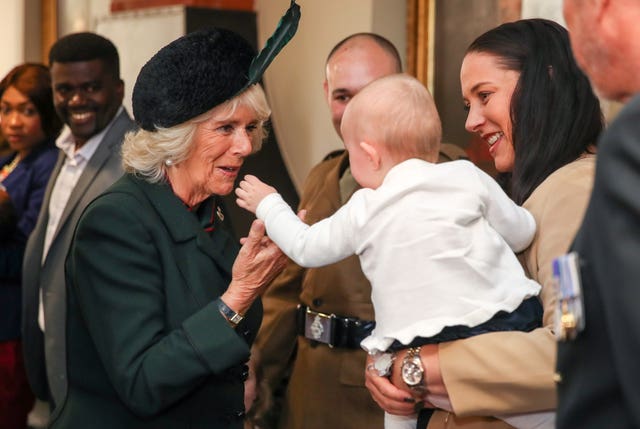 The Duchess of Cornwall meeting one year old Cara May Campbell and mother Sarah Campbell as she attends the medal parade. Andrew Matthews/PA Wire
