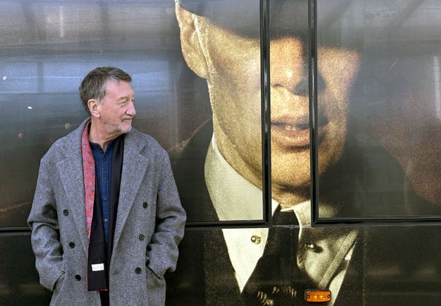 Steven Knight beside the tram which features an image of Cillian Murphy as Tommy Shelby