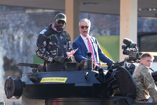 Derek Chisora (left) arrives with Reform UK leader Nigel Farage on top of a tank