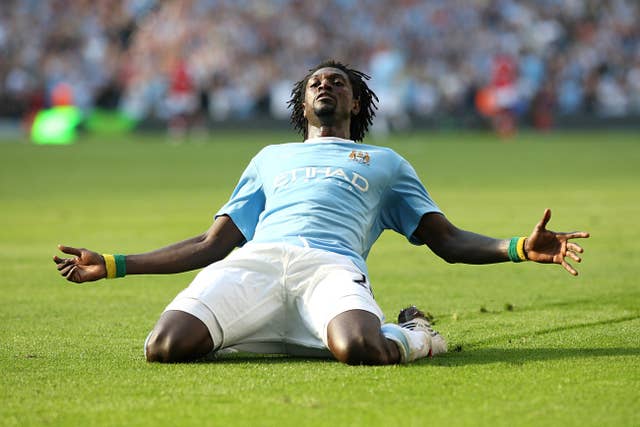 Emmanuel Adebayor celebrates with a knee-slide in front of the Arsenal fans after scoring for Manchester City