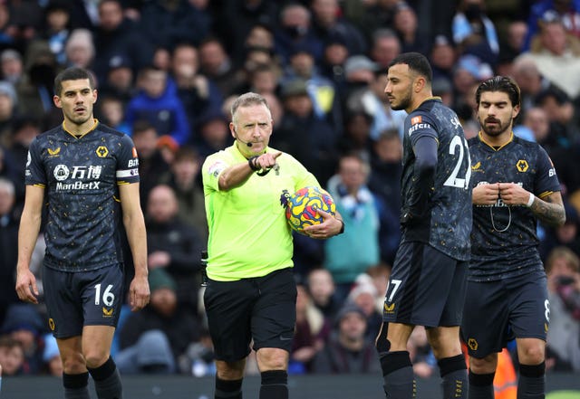 Jon Moss, centre, awards a penalty to Manchester City