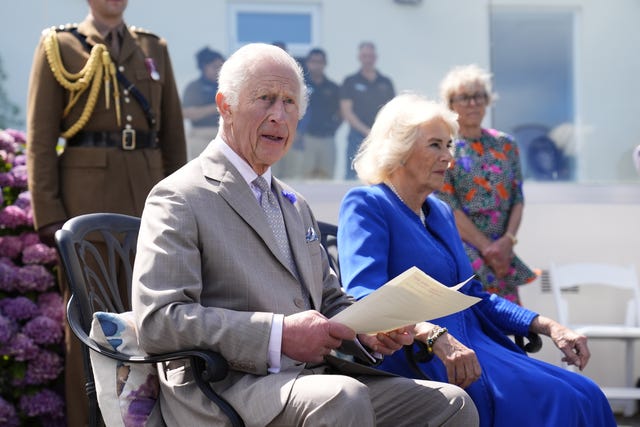 The King reading a statement to Alderney islanders with the Queen at his side during a visit to Guernsey