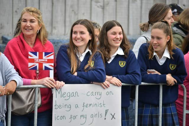 School students held homemade signs as they hoped to catch a glimpse of the couple