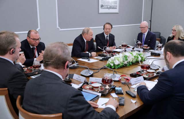 Vladimir Putin, centre, with heads of international news agencies at the St Petersburg International Economic Forum (Michael Metzel/TASS/PA)