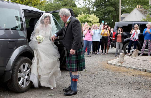Rose Leslie is helped out of her wedding car by her father