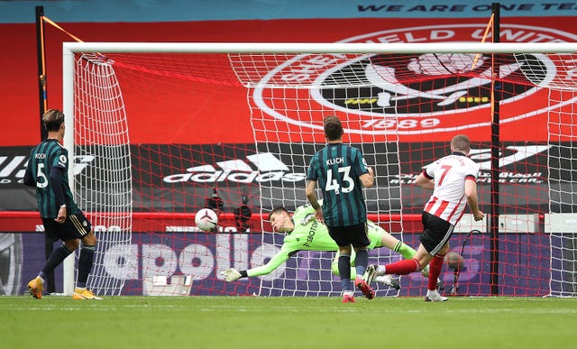 Illan Meslier saves from John Lundstram, right