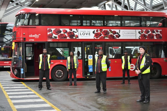 Staff stand inside Camberwell bus depot observe the minute’s silence
