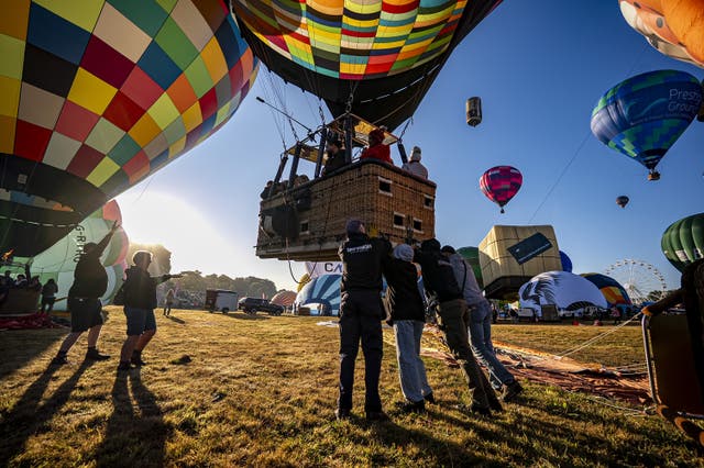 Crews pushing hot air balloons into position