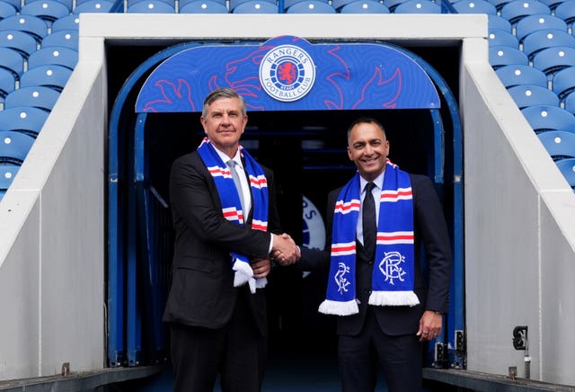 Rangers chairman Andrew Cavenagh (left) and Paraag Marathe shake hands in front of the tunnel at Ibrox