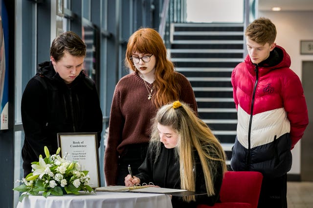 Youngsters sign a book of condolence in Cookstown for the families of three teenagers who died outside the Greenvale Hotel 