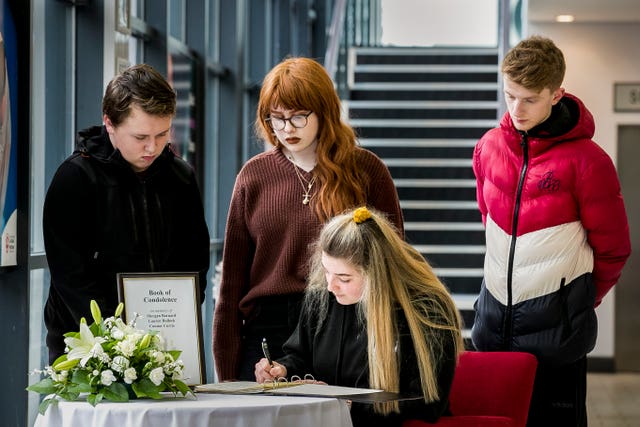 Youngsters sign a book of condolence in Cookstown for the families of three teenagers who died outside the Greenvale Hotel