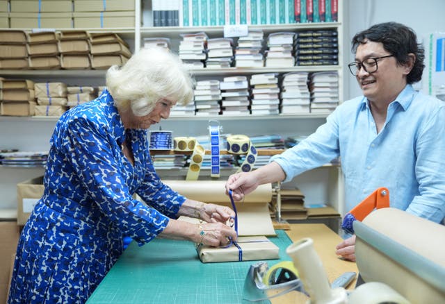Camilla helps pack a book for delivery with packer Jay Lomot