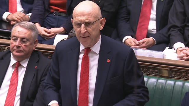 John Healey standing while delivering the Budget statement in the Commons