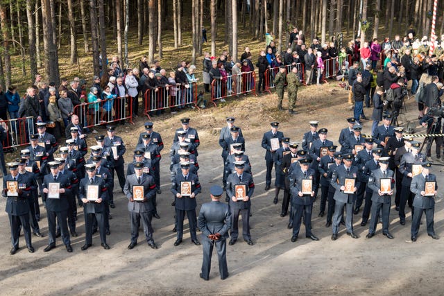 Air force personnel parade at the former site of Stalag Luft III in Zagan, Poland, during a remembrance service to commemorate the 75th anniversary of the Great Escape