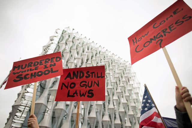 Protesters hold up signs during the London March For Our Lives anti-gun rally outside the US Embassy in London (Stefan Rousseau/PA)