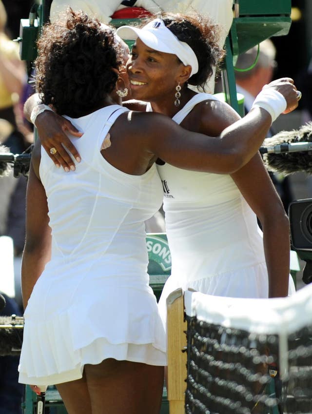 Serena and Venus hug each other at the net