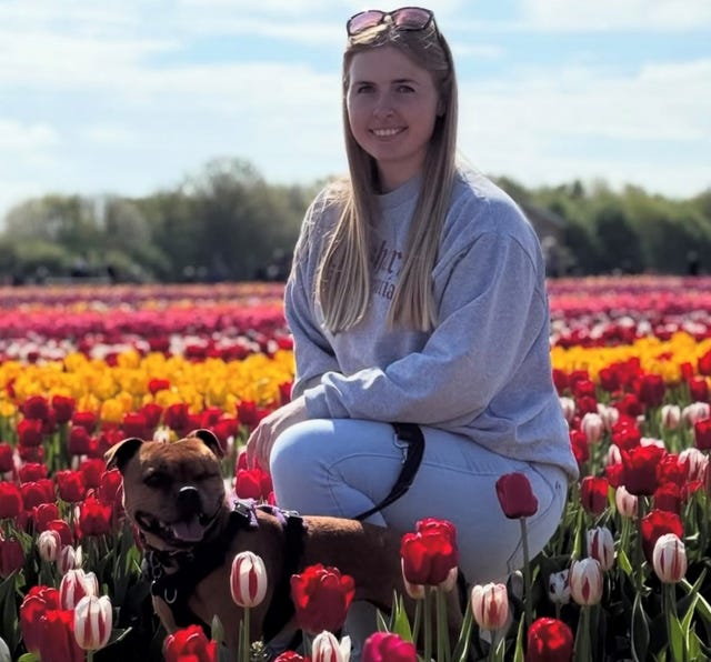 Jennie Logan in a field of flowers with a dog