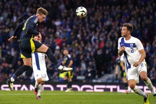 Scotland''s Tommy Conway, left, heads at goal against Finland