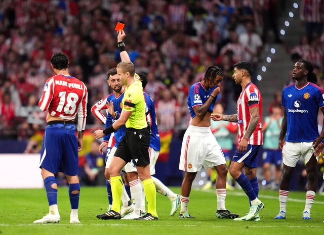 Referee Glenn Nyberg shows a red card to Manchester United’s Leny Yoro