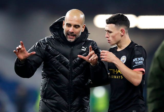 Manchester City manager Pep Guardiola celebrates the victory with Phil Foden