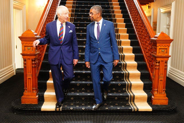 The King with Vaughan Gething standing at the bottom of a staircase