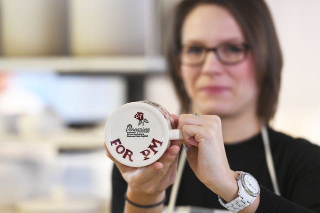 Pottery maker holds PM cup