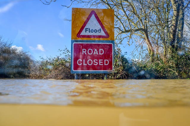 A road closed sign pokes out above floodwater and alerts motorists of flooding on the B4213 between Lower Apperlay and Tirley in Gloucestershire (Ben Birchall/PA)