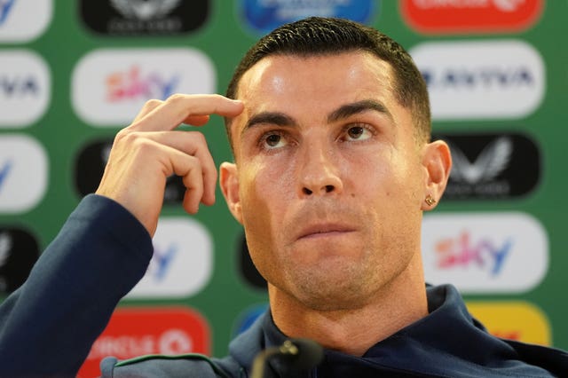 Cristiano Ronaldo puts his fingers to his temple in a press conference