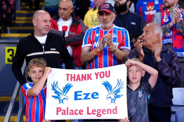 Crystal Palace fans in the stands hold up signs thanking Eberechi Eze