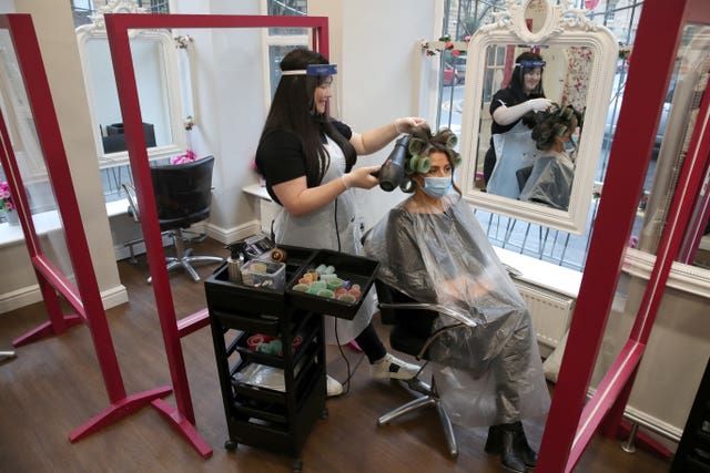 Salon manager Gemma Inglis works on the hair of Shireen Inglis at The Lunatic Fringe in Glasgow