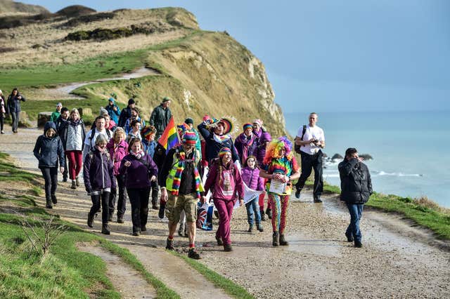Natalia Spencer joined by dozens of supporters as she finishes her 6,000 mile walk around the coast of Britain (Ben Birchall/PA)