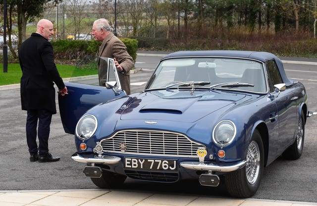 The Prince of Wales with his Aston Martin DB6 as he arrives for a visit to the Aston Martin Lagonda factory in Barry (Rebecca Naden/PA).