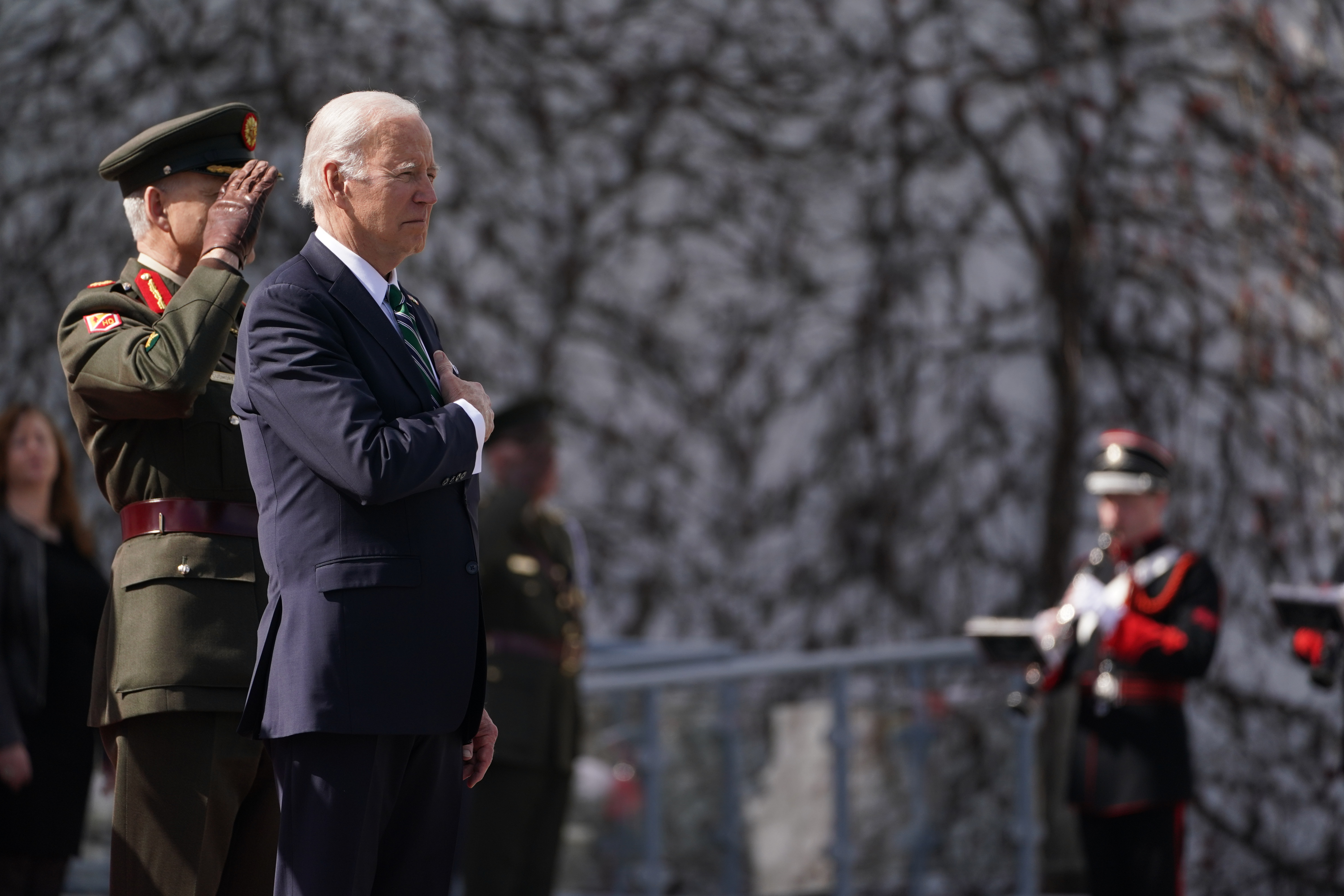 US President Joe Biden stands for the national anthem as he arrives for a meeting with Irish President Michael D Higgins at Aras an Uachtarain, in Phoenix Park, Dublin