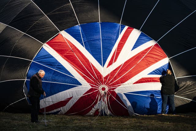 Crews checking the crown of a hot air balloon with a Union flag design