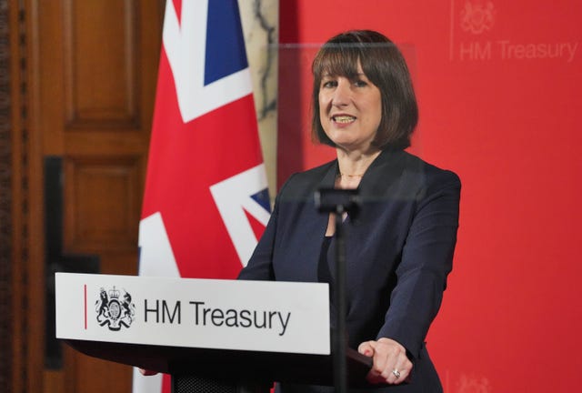 Rachel Reeves behind a lectern reading HM Treasury with a Union flag in the background